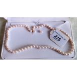 A uniform sized cultured pearl necklace with a pair of cultured pearl earrings en-suite.