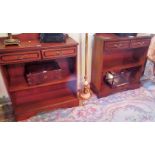A pair of reproduction low bookcases, each having shaped upstand over rectangular top,