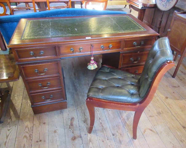 A reproduction mahogany veneered twin pedestal desk with green hide inset top,