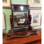 A Victorian mahogany toilet mirror, the rectangular plate within a cushion frame,