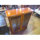 A reproduction display cabinet, the rectangular top over a pair of glazed doors,