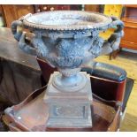 A 19th century cast iron replica of the Warwick urn, on a stepped square plinth, 40 x 38cm.