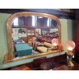 A gilt composite over mantle mirror, the reeded frame with fan corners enclosing a bevelled plate.