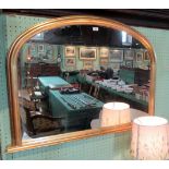 A gilt composite over mantle mirror with plain arched plate.
