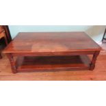 A fruitwood coffee table, the rectangular top on ring turned and block supports united by undertier.