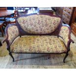An Edwardian parlour settee, the cartouche shape padded back with inlaid floral details,