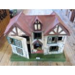 A mid-20th century timber constructed dolls house, having a twin pitched roof with dormer window,