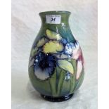 A Walter Moorcroft green ground ovoid pottery vase,