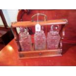 An Edwardian three bottle oak framed tantalus.