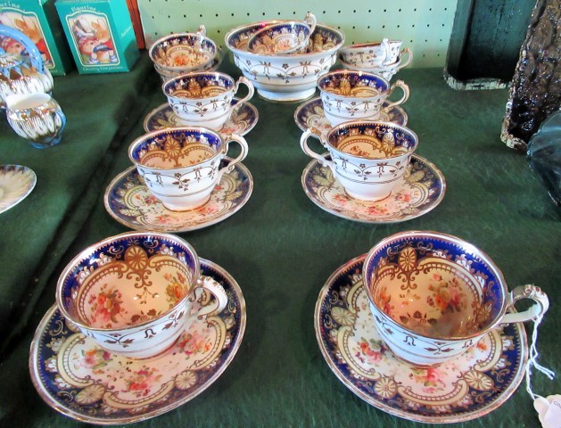 A Victorian English bone china part-tea service, decorated with blue borders and cut flowers.