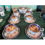 A Victorian English bone china part-tea service, decorated with blue borders and cut flowers.