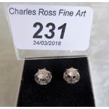 A pair of diamond single stud earrings.