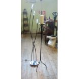 A contemporary black metal three light standard lamp, together with a black painted candle stand.