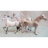 Three Beswick dapple grey horses, two modelled standing, the other trotting, each gloss glazed.