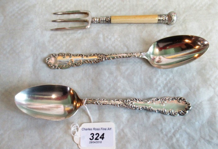A pair of early 20th century American sterling silver serving spoons, with cast scrolling edges,