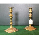 A pair of late 17th/early 18th century petal based brass candlesticks.