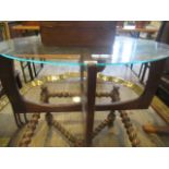 A 1970's G-Plan-style coffee table, the oval glass top on a simulated rosewood support.