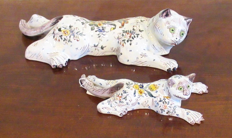 A pair of French faience wall pockets, each florally decorated and modelled as a recumbent cat.