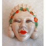 A 1930's Clarice Cliff wall pocket, modelled as an Asian lady wearing headdress and floral garland,