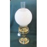 An Edwardian brass paraffin lamp with spherical opaque shade.