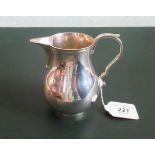 A 20th century heavy silver sparrow beak cream jug with capped scroll handle, London 1957.