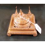 A 19th century brass inkstand with twin dolphin pen rest and hinged dome cover,