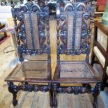 A pair of Carolean-style oak hall chairs, each with scrolling crown rail,