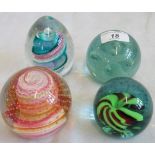 A collection of four decorative glass paperweights, to include: two Caithness,