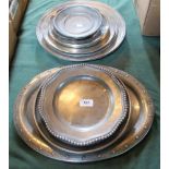 A collection of 18th/19th century-style pewter platters, serving trays and small waiters.