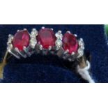 A ruby and diamond half-hoop ring, the oval cut rubies with two brilliant cut diamond spacers,