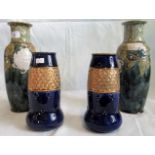 A pair of Royal Doulton slipware trailed stoneware baluster vases and two other blue and gilt Royal