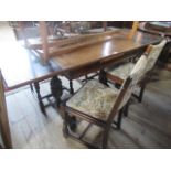 A circa 1930's oak drawer leaf dining table, on florally carved cup and cover supports,