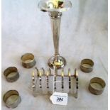 A silver trumpet shape vase with loaded base, a silver toast rack and five serviette rings,