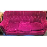 An early 20th century red claret button plush upholstered three person settee.