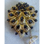 A sapphire and diamond cluster pendant brooch of pierced shield shape,