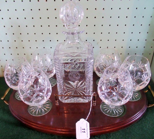 A cut glass spirit decanter and six glasses, on a brass mounted mahogany serving tray.