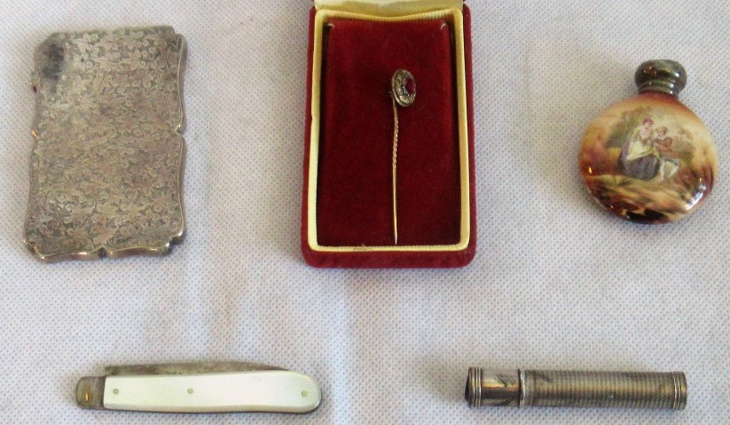 A silver card case, penknife, scent bottle, lapel pin and a white metal lady's mood indicator.