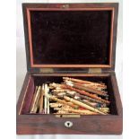 A 19th century rosewood hinge lidded box, containing multiple mainly Bedford-type lace bobbins,