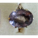 A single stone amethyst dress ring, the large oval cut stone in raised claw mounts,