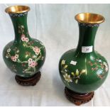 A pair of 20th century jade green ground Oriental cloisonne vase on carved wooden stands.