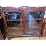 An Edwardian mahogany bookcase, having a a caddy top over fluted and swag moulded frieze,