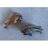 A pair of snap clasp silver earrings, each fashioned as a pair of swimming dolphins.