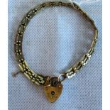 A 9ct gold gate link bracelet with heart padlock clasp. Condition Report: 8.8 grams.