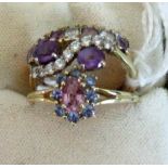 Three gem set dress rings, including an amethyst crossover ring.