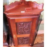 A reproduction wall mounting corner cupboard, having a pair of florally carved panel doors,