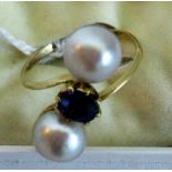 A sapphire and pearl crossover ring, the oval circular set sapphire in a claw mount,