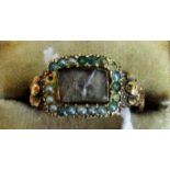 An early Victorian mourning ring, the rectangular glazed hair panel within a border of split pearls,