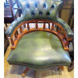 A reproduction green button hide upholstered captain's swivel armchair.