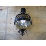 A 20th century wrought iron hanging lamp with coloured glass globe.