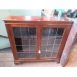 An early 20th century mahogany glazed two door bookcase on ogee bracket feet.